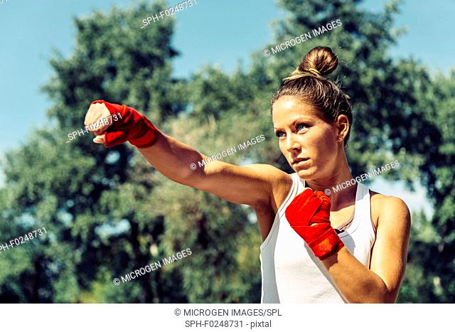 Young woman doing Tae Bo direct punch