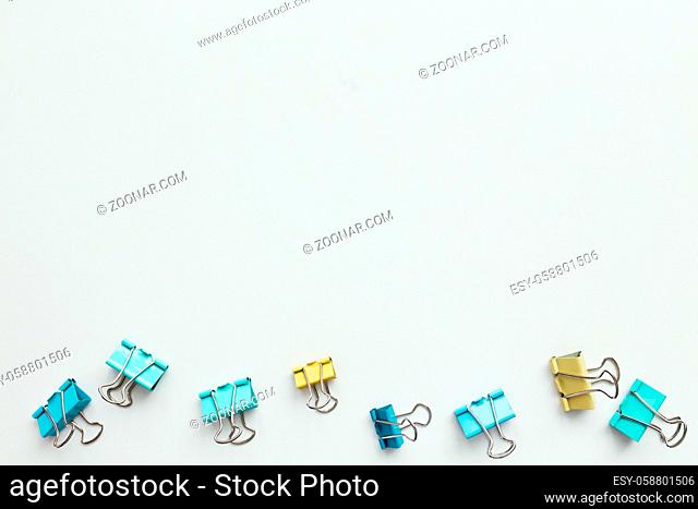 Blue and yellow paper clips on white background. Work and education concept. High quality photo