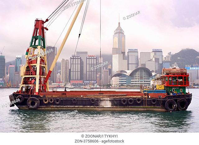 Hong Kong S.A.R. - MAY 19, 2012: Barge in front of business district in Hong Kong.Some 456, 000 vessels arrived in and departed from Hong Kong during the year
