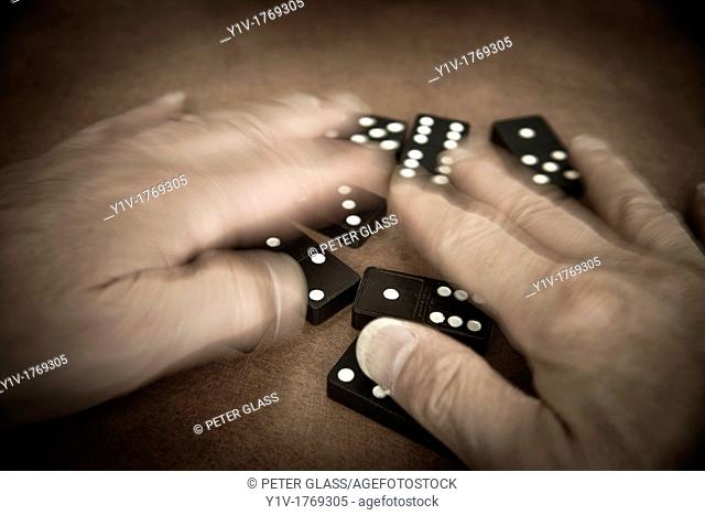 Man's hands playing with dominoes
