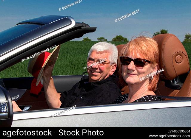Happy senior couple in sports car