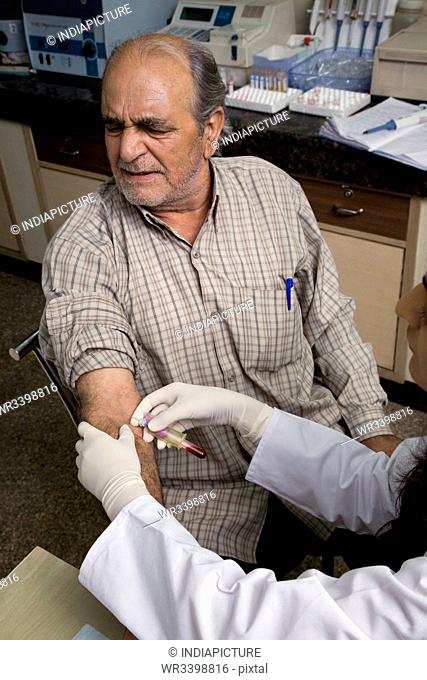 Doctor taking a blood sample from a man