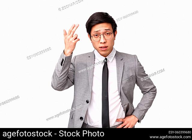 Waist-up portrait of serious-looking disappointed young asian businessman complaining, disapprove bad project, unproductive work