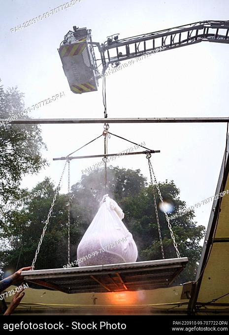10 September 2022, Hessen, Schotten: A fire department crane is used to lift a bread dumpling weighing over 100 kilograms out of hot water on the Hoherodskopf...