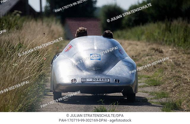 Initiator Horst-Dieter Görg (l) and mechanic Peter Langner driving in the half-finished reconstruction of a 1938 Hanomag Rekord car on a field track near...