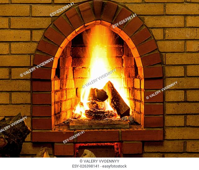 spurts of fire in brick fireplace in country cottage