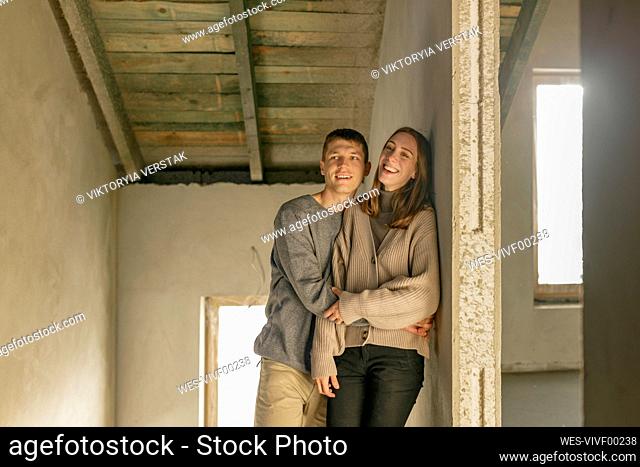 Young man hugging woman at home