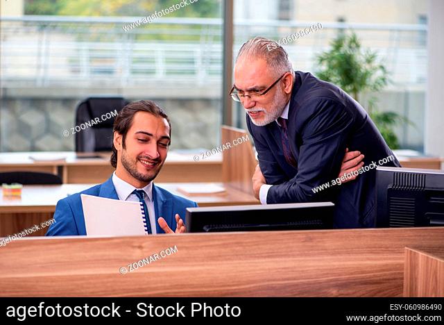 Two businessmen employees sitting in the office
