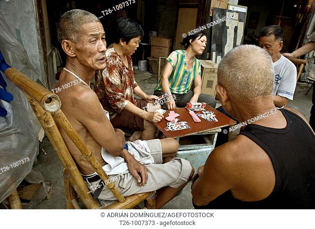 man smoking and playing cards. Ping Le, China