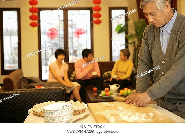 Chinese mature man make Chinese dumpling on New Year's Eve
