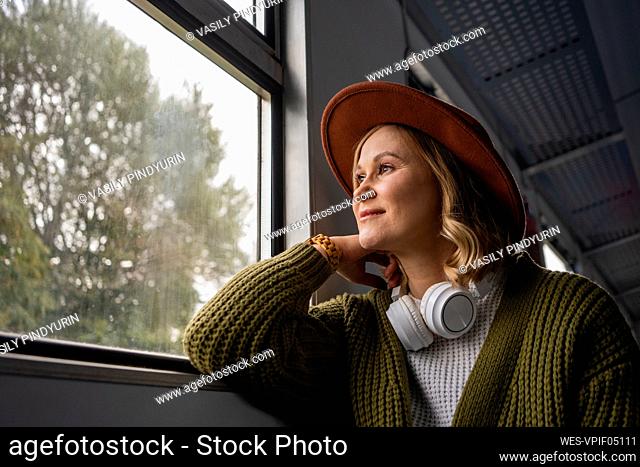 Woman looking through window while travelling in train