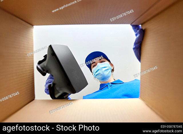 woman in mask packing vr glasses to parcel box