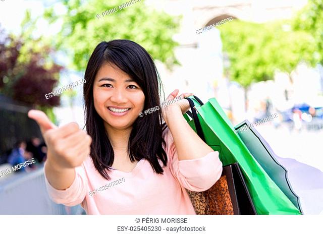 View of a Young attractive asian tourist doing shopping in Paris
