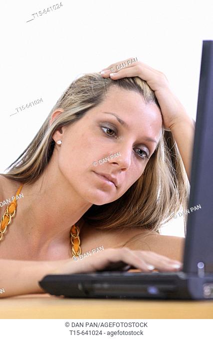 Woman working on her laptop exhausted and tired