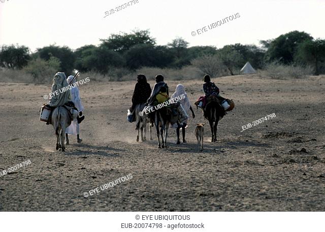 Baggara Arabs from the Beni Halba tribe on foot and donkey in semi desert area