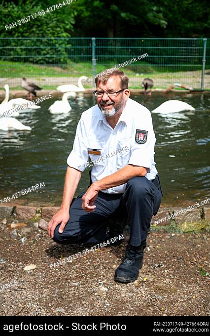 PRODUCTION - 04 July 2023, Hamburg: Swan father Olaf Nieß sits by a pond in the Swan Quarter. For 27 years, swan father Olaf Nieß has taken care of the majestic...