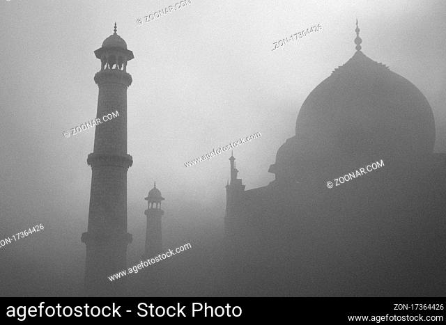 Taj Mahal at sunrise on a misty winter day. A monochrome photo. Taj Mahal, which is the mausoleum built for Mumtaz Mahal by her husband