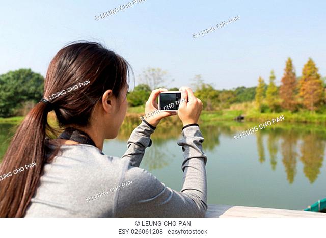 The back view of Young woman taking picture by digital camera