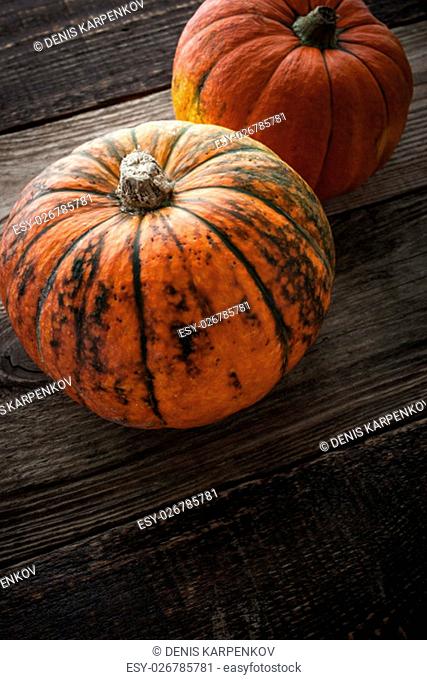 Pumpkins with green stripe on the wooden table vertical