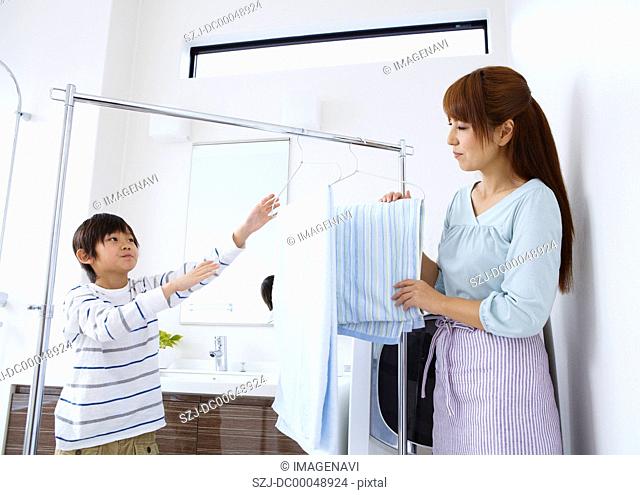 Mother and son hanging out laundry