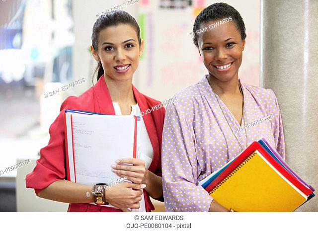 Portrait of smiling businesswoman with folders