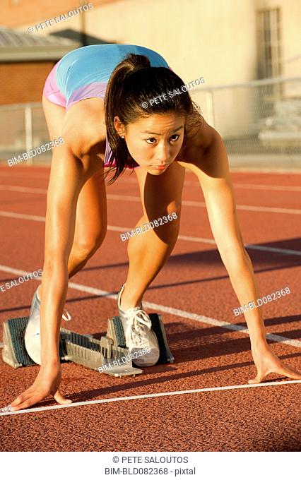 Japanese runner preparing to start race on racetrack
