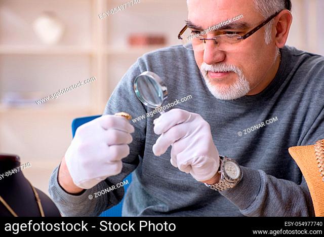 White bearded old jeweler at workshop