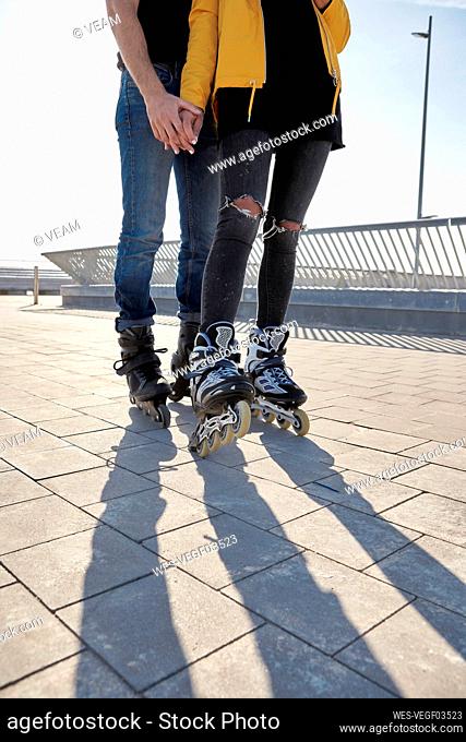 Heterosexual couple with roller skate standing on pier