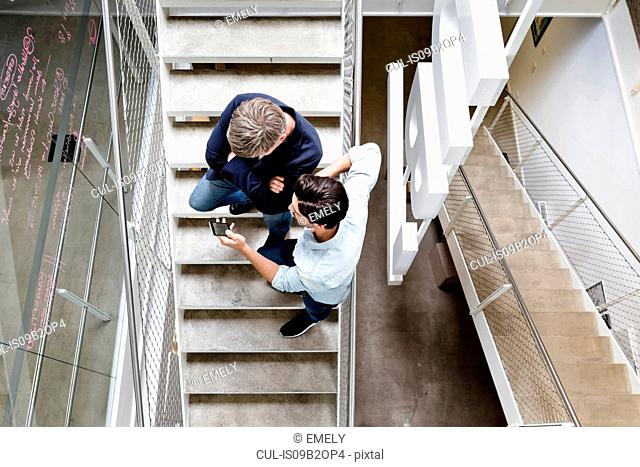 Colleagues on stairway looking at smartphone