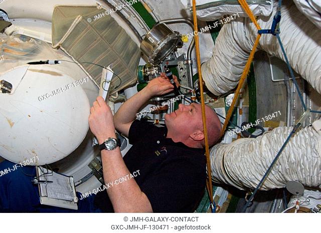 European Space Agency astronaut Andre Kuipers, Expedition 30 flight engineer, conducts a leak check in the Zvezda Service Module transfer tunnelATV vestibule of...