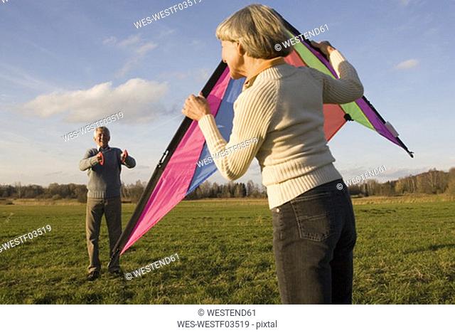 Germany Bavaria, Ammersee, Senior couple flying kite