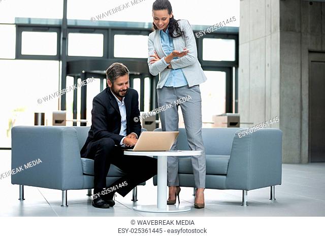 Businessman having a discussion with colleague over laptop