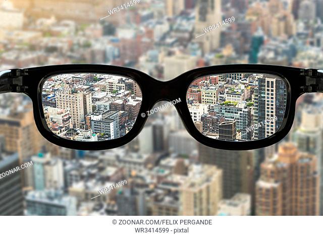 cityscape view focused in glasses lenses, vision concept