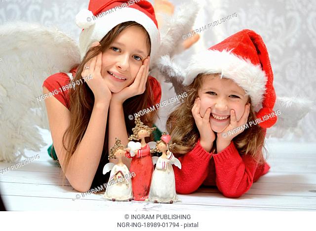 Two delighted sisters with toy angels