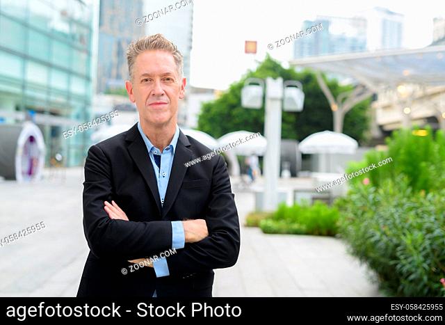 Portrait of mature businessman in suit in the city streets outdoors