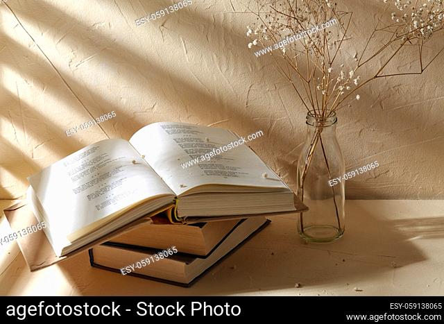 books and decorative dried flowers in glass bottle