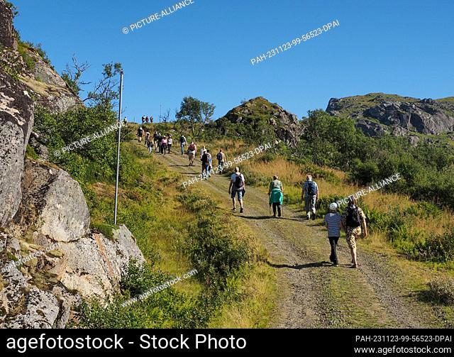 26 August 2023, Norway, Leknes: Excursionists from a cruise ship hike along a path in the mountains near Leknes. Photo: Soeren Stache/dpa