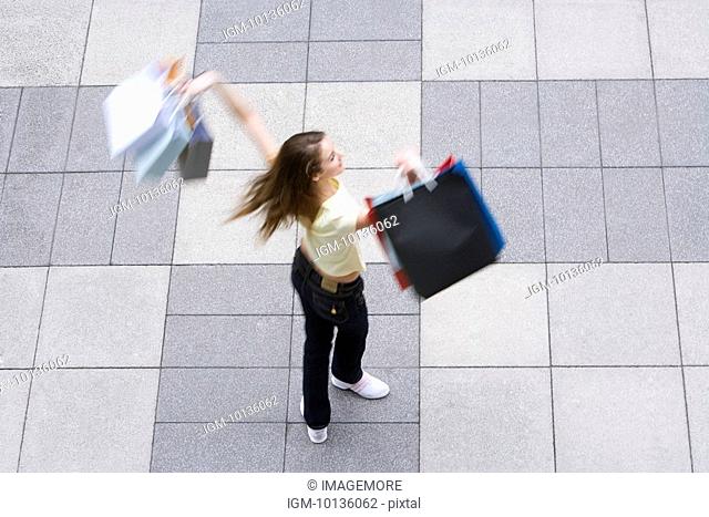 Teenage girl holding up shopping bags