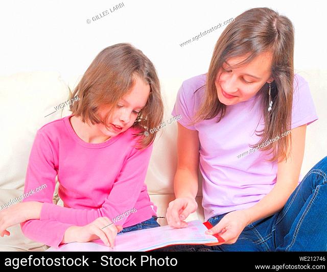 Two sisters student on the couch with a notebook