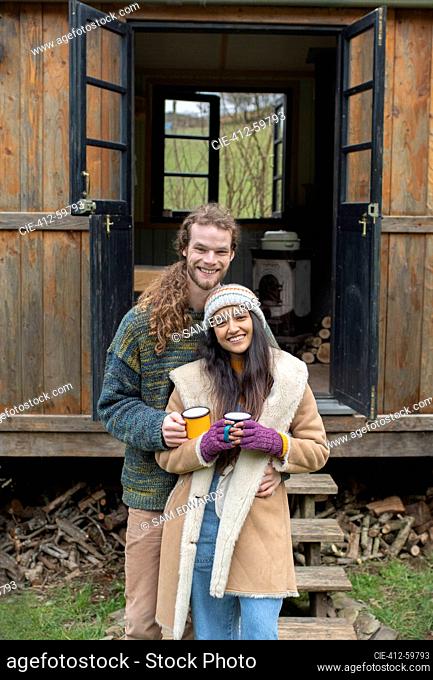 Portrait happy couple outside tiny cabin rental