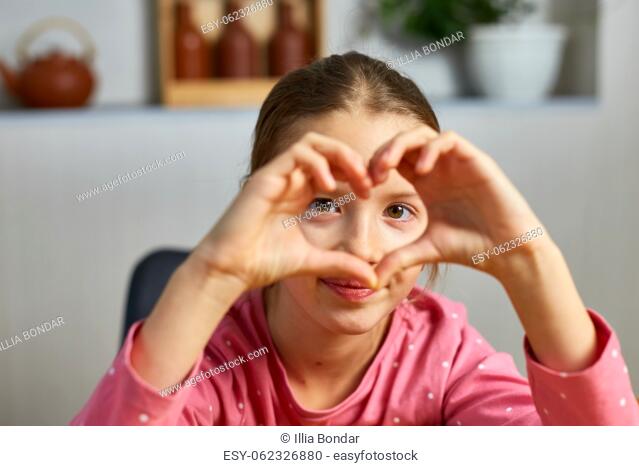 Little girl, making hearts from hands, love, casual cheerful cute funny girl showing heart shape sign with fingers