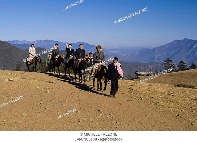 Tourists horse riding at Maoniuping, Yulong Xueshan Mountain, Lijiang, Yunnan Province, China