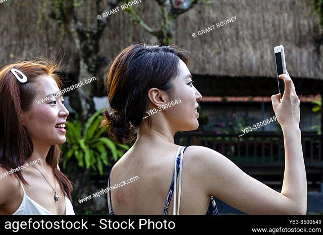 Asian Tourists Taking Photos At Pura Taman Saraswati, Bali, Indonesia