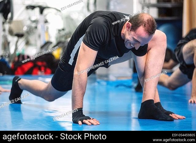 Fitness man warming up in gym. Preparing kick boxing combat