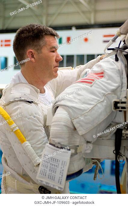 Astronaut Stephen G. Bowen, STS-126 mission specialist, works with a training version of the Extravehicular Mobility Unit (EMU) spacesuit in preparation for a...