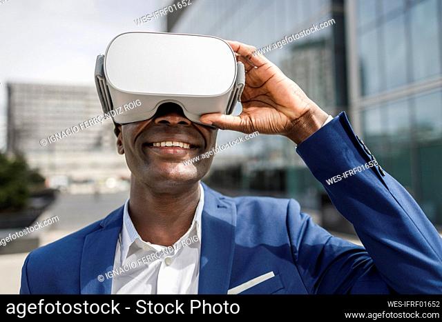 Happy businessman wearing virtual reality simulator