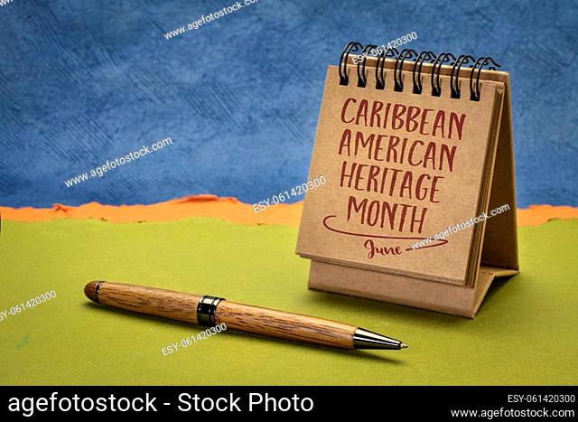 Caribbean American Heritage Month - handwriting in a small desktop calendar against abstract paper landscape, reminder of the annual cultural event