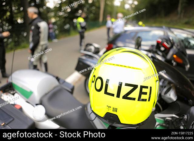 Symbolbild Polizeikontrolle, vorne Motorradhelm hinten kontrollierende Polizeibeamte, Wipperfürth, Bergisches Land, NRW; Deutschland