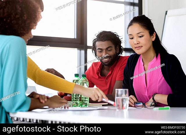 Businesswoman explaining business strategy to male and female colleague in office