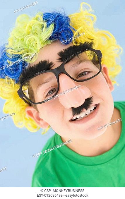 Young boy wearing clown wig and fake nose